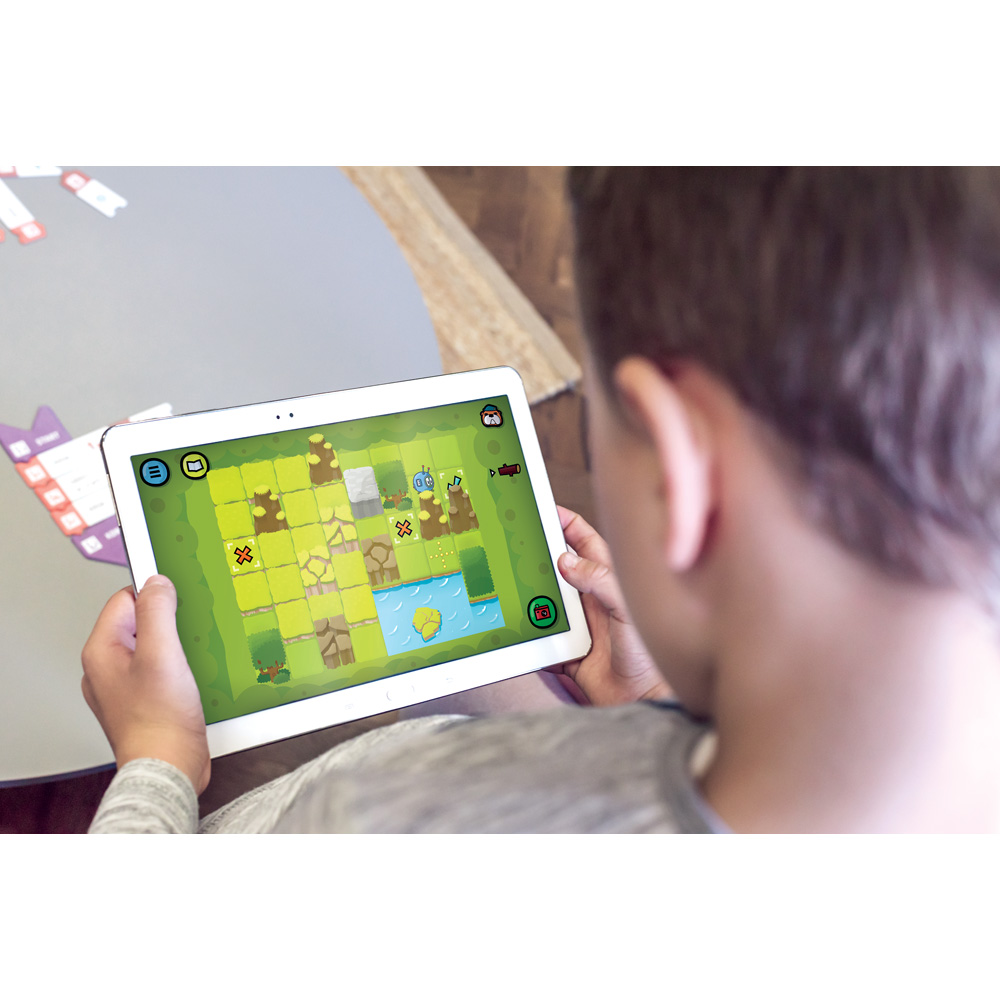 Chlapec hrající vzdělávací hru na tabletu s barevným herním plánem