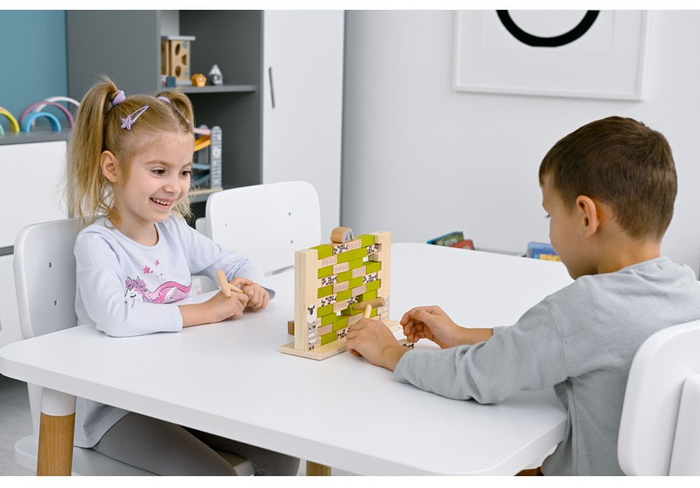 Dvě děti hrají dřevěnou hru Nestabilní stěna a procvičují soustředění i koordinaci.